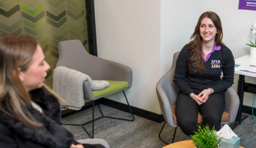 A woman speaks with an Open Arms staff member