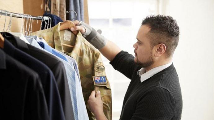 man hanging up army uniform