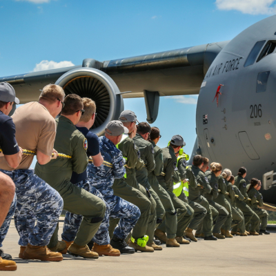 ADF members pull an Air Force plane with a rope